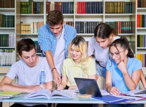 Group of teenage students study in library class