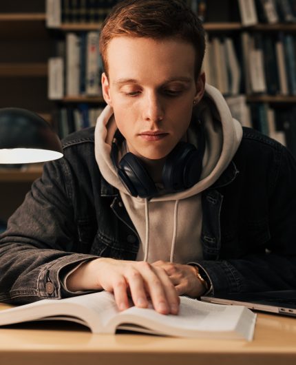 Male student reading from a book